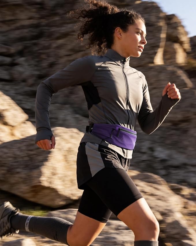 WATERFLY Running Belt Fanny Pack: Breathable 3 Pocket Waist Bag for Men Women Workout Exercise Fitness Phone Holder Fits All Phones - Runner Marathon Jogging Race Belt with Bib Clip Purple